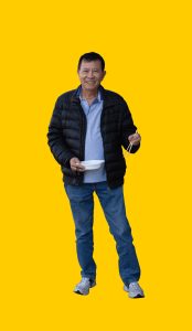 01 Gelber Hintergrund, davor ein Mensch mit Schüssel und Essstäbchen