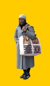 05 Gelber Hintergrund, davor ein Mensch im Portrait mit Plastikeinkaufstasche