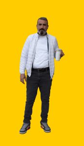 08 Gelber Hintergrund, davor ein Mensch im Portrait, der einen Trinkbecher in der Hand hält