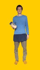 16 Gelber Hintergrund, davor ein Mensch im Portrait, der ein Dose mti Müsli in der Hand hält