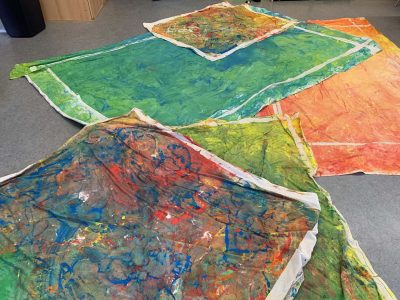 großfromatige Leinwände auf dem Boden farbig bemalt